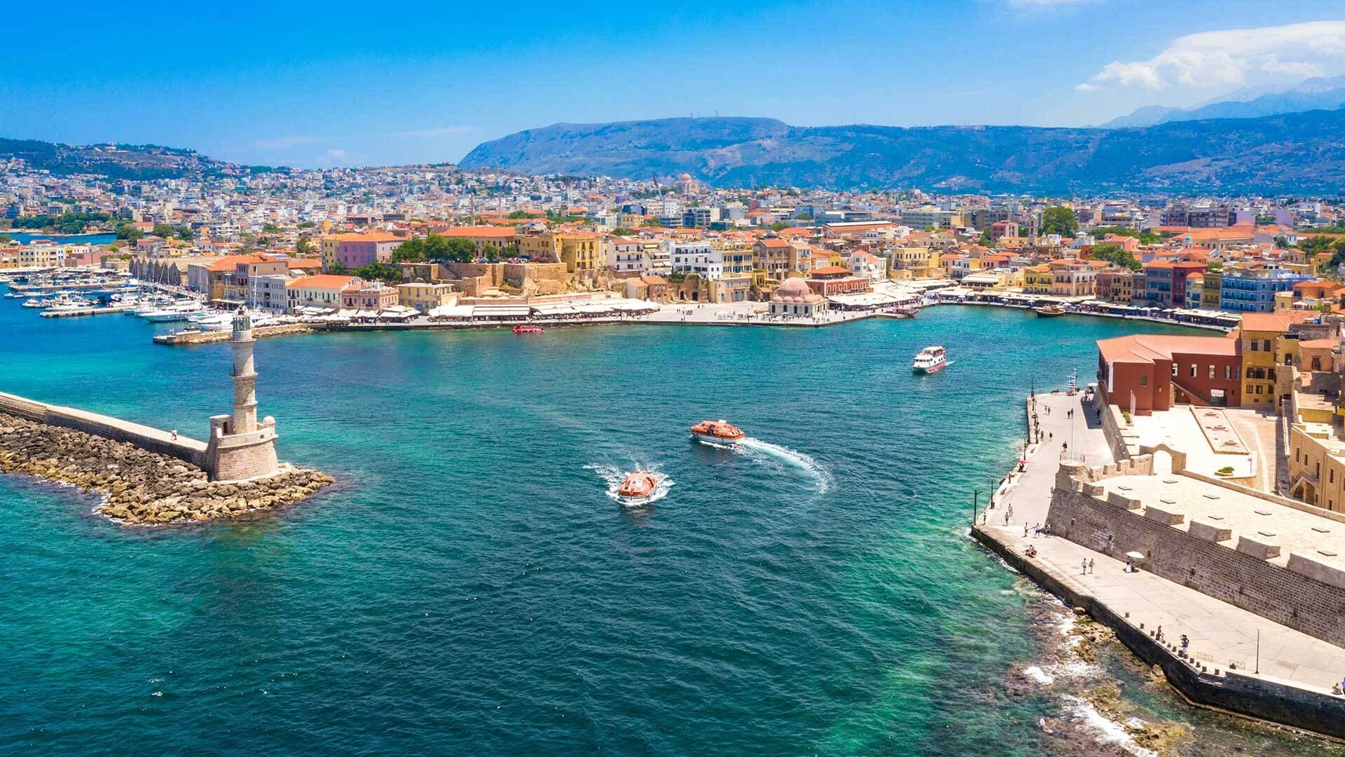 Το ενετικό λιμάνι των Χανίων με τον φάρο και τα πολύχρωμα κτίρια να αγκαλιάζουν τη θάλασσα.