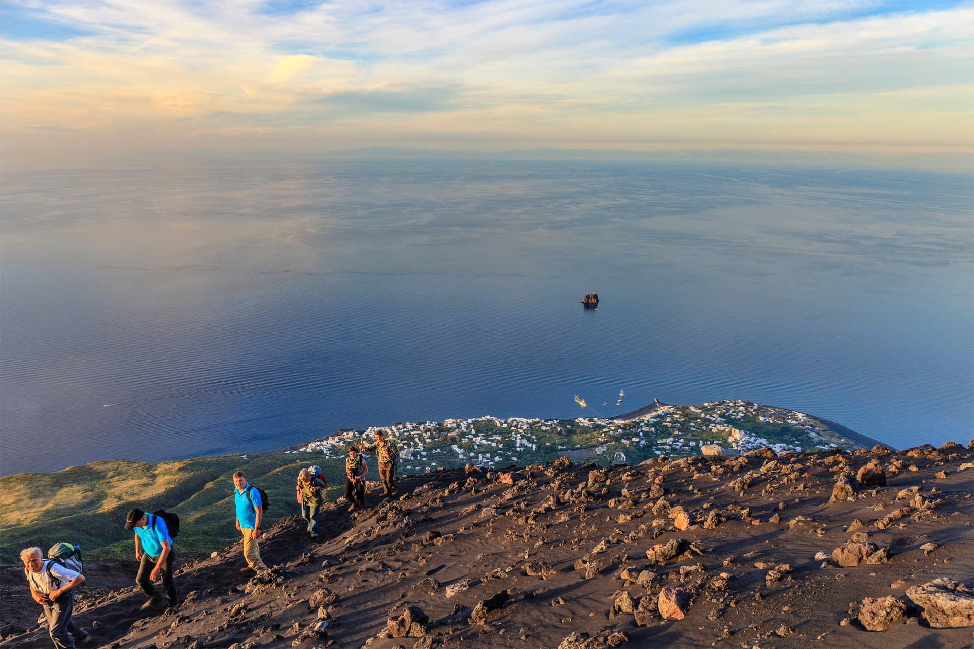 Un groupe de randonneurs sur les hauteurs du Stromboli face à l'immensité de la mer au coucher du soleil